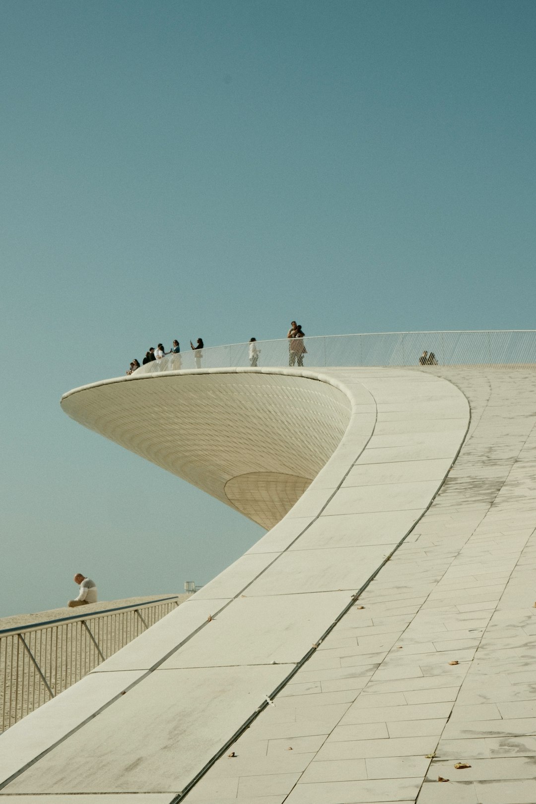 a-group-of-people-standing-on-top-of-a-tall-building-gugyqfnkhpq